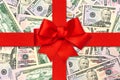 Red gift ribbon bow over american dollars Royalty Free Stock Photo