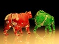 Red glass bear figure confronts green glass bull figure