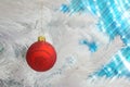Red glass glitter ornament Christmas bauble hanging on a white Christmas tree Royalty Free Stock Photo