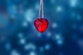 Red glass heart on blue glitter lights background. Image Royalty Free Stock Photo