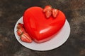 Red glaze mousse cake, heart shape form on dark background