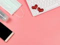 Red glitter heart on computer keyboard , mobile phone,  medical  mask and sanitizer gel on pink background. Covid19 prevention, Royalty Free Stock Photo