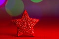 Red glitter star Christmas decoration isolated on background of bokeh lights Royalty Free Stock Photo