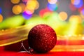 Red glittery decoration in a colorful Christmas composition isolated on background of blurred lights Royalty Free Stock Photo