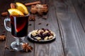 Red glogg or mulled wine with orange slices and cinnamon stick on dark wooden background, horizontal, copy space