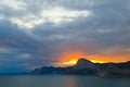 Red glow in the sky over the mountain at sunset on the Black sea in Crimea, Sudak Royalty Free Stock Photo