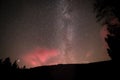 Red glowing sky at night with stars milky way and shooting star at big Arbersee in bavarian forest, Germany Royalty Free Stock Photo