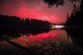 Red glowing sky at night with stars milky way and shooting star at big Arbersee in bavarian forest, Germany Royalty Free Stock Photo