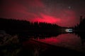 Red glowing sky at night with stars milky way and shooting star at big Arbersee in bavarian forest, Germany Royalty Free Stock Photo