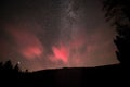 Red glowing sky at night with stars milky way and shooting star at big Arbersee in bavarian forest, Germany Royalty Free Stock Photo