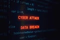 Red glowing text C Y B E R A T A C K and D A T A B R E A C H on dark computer code screen cybersecurity 1 Royalty Free Stock Photo