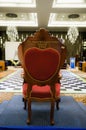 a red and gold chair sitting in a room with blue carpet