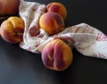 Close up of peaches on a table next to a kitchen towl Royalty Free Stock Photo