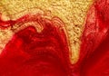 Red and gold nail polish fluid texture.