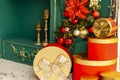 Red and gold New Year`s balls on a fir branch next to New Year`s gifts and a green fireplace Royalty Free Stock Photo