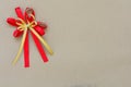Red and gold satin bow ribbon on brown paper background Royalty Free Stock Photo