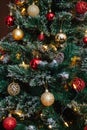 Red and golden balls on a Christmas tree with lights and bokeh Royalty Free Stock Photo