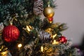 Red and golden balls on a Christmas tree with lights and bokeh Royalty Free Stock Photo