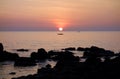 Red Golden Ocean Sunset with Boat From Rocky Shore Royalty Free Stock Photo