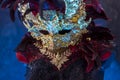 Red golden venetian carnival mask with feathers on a draped red Royalty Free Stock Photo