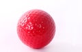 Red golf ball on red tee, white background Royalty Free Stock Photo