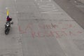 Red graffiti over pavement `la vida se respeta` or Respect life with a motorcycle and colombian flag