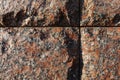 Red granite bricks masonry wall with grooves in shape of a cross Royalty Free Stock Photo