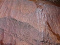 Red granite surface by flowing water over it. Royalty Free Stock Photo