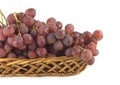 Red grape on branch in straw wicker basket isolated Royalty Free Stock Photo