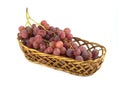 Red grape on branch in straw wicker basket isolated Royalty Free Stock Photo