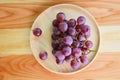 Red grape bunch on wooden plate on a table Royalty Free Stock Photo