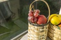 Red grapes and red apples in the basket. There is also a mandarin at the back. Fresh fruits in the basket.Picnic basket.