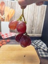 red grapes being held in hand background wood