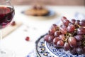 Bunch red grapes in blue bowl, , glass of red wine, against blur background Royalty Free Stock Photo