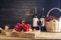 Red grapes with a bunch of grapes in a sweet natural fruit wooden basket with a wine bottle Placed on the table, black and dark Royalty Free Stock Photo