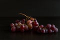 Red grapes, large bunch of fruits, fresh and tasty simple food on a dark background in a fancy minimal composition