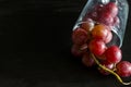 Red grapes, large bunch of fruits, fresh and tasty simple food on a dark background in a fancy minimal composition