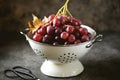 Red grapes in a white colander on a gray background. Royalty Free Stock Photo