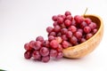 Red grapes in a woodenn bowl isolated on white background. Fresh bunch of fruits. Selective focus