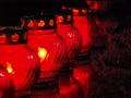 Red grave candles standing in a row in a cemetery at night Royalty Free Stock Photo