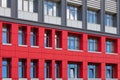 Red-gray modern ventilated facade with windows. Fragment of a new elite residential building or office center