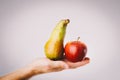 Red and green apple and pear held in male hands. Conceptual for comparison, differentiation and selection Royalty Free Stock Photo