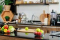 Red and green apples in glass bowl ready to slice with knife on wooden cutting board placed on cooking countertop with vegetables Royalty Free Stock Photo