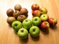 Red and green apples, and kiwi fruit on wooden table Royalty Free Stock Photo