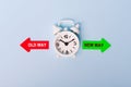 Red and green arrows - direction indicator - choice of old or new way. Concept of choice. Two Arrows and White alarm clock on blue Royalty Free Stock Photo