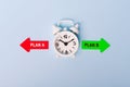 Red and green arrows with text Plan a vs plan b. Concept of choice. Two Arrows and White alarm clock on blue background, top view Royalty Free Stock Photo