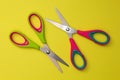 Red and green baby scissors isolated on a yellow background Royalty Free Stock Photo