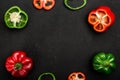 Red and green bell peppers or sweet peppers or capsicums whole, cut in half and slices on dark board