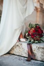 Red-Green bridal bouquet at the feet of the bride Royalty Free Stock Photo