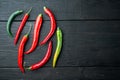 Red and green chili pepper, on black wooden table background, top view flat lay  , with copyspace  and space for text Royalty Free Stock Photo